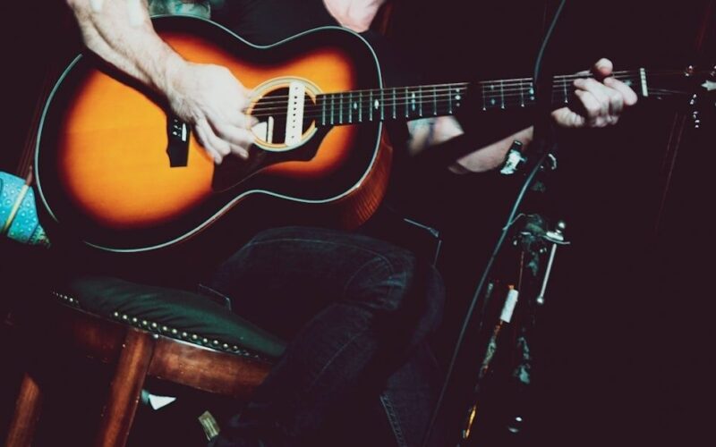 Gros plan sur un musicien jouant de la guitare acoustique sur scène