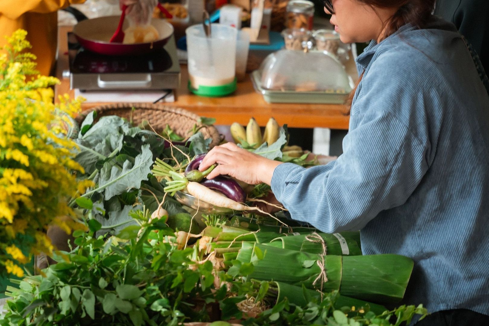 Une cuisinière trie des légumes frais dans une cuisine