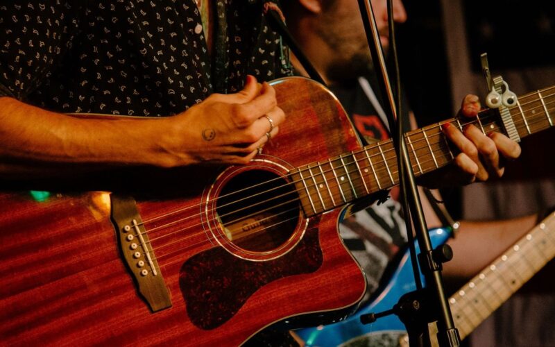 Gros plan sur un guitariste jouant de la guitare acoustique sur scène